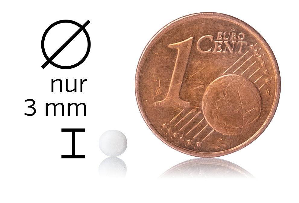 Mikropille 3 mm – weiße Tablette Weiße Mikropille mit einem Durchmesser von 3 mm neben einer 1-Cent-Münze auf einem weißen Hintergrund.