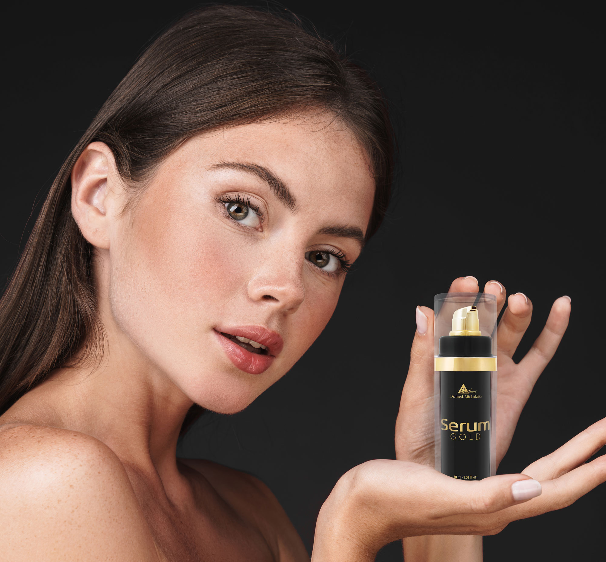 Serum Gold 30 ml – Pumpflasche Gesichtsserum in einer eleganten Pumpflasche, 30 ml, schwarz-goldene Verpackung, in der Hand einer Frau präsentiert.