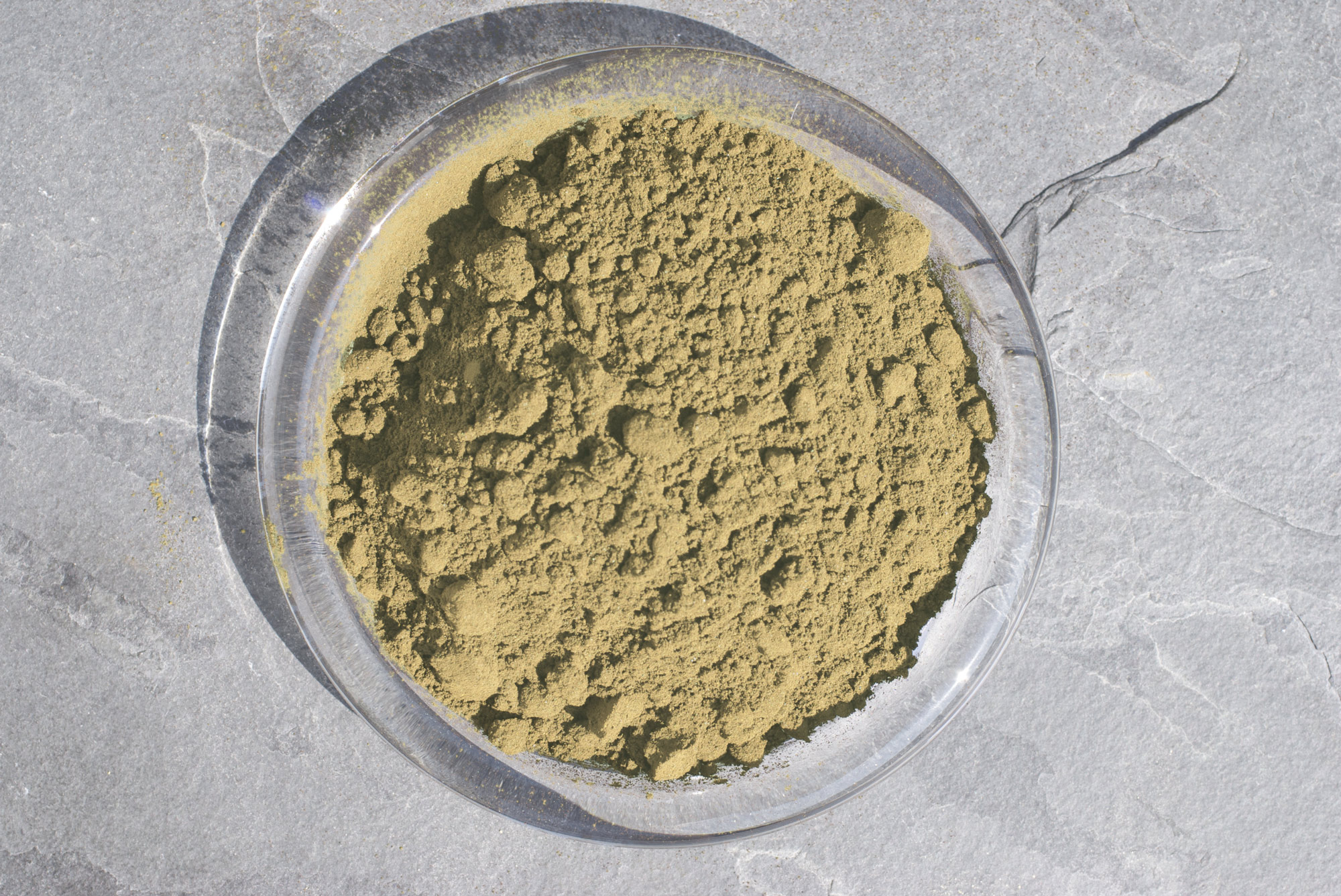Kräuterpulver – 100 g Feines Kräuterpulver in einer klaren Schale, braun-grünlich, aus Sicht von oben.