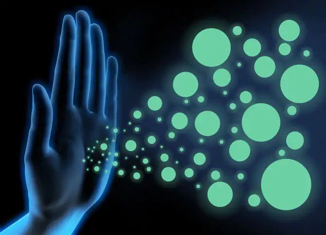 Hand und Viren - Immunsystem Abwehr Vorsorge Corona Grafische Darstellung einer Hand, aus der grüne Partikel und Kreise strömen, vor schwarzem Hintergrund.